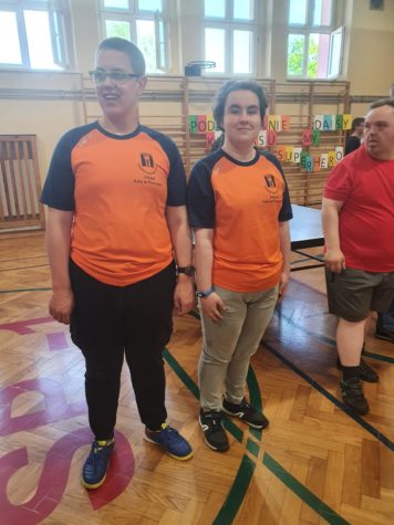 Na fotografii Paulina i adrian w pomarańczowych koszulkach na sali gimnastycznej.
