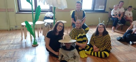 Na fotografii uczniowie przebranie za pszczoły i pszczelarza wraz z opiekunem przed występem.