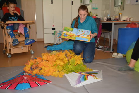 Na zdjęciu Pani Ewa bibliotekarka czyta bajkę o jesiennych zabawach w Stumilowym Lesie.