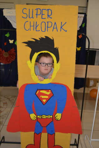 Na fotografii chłopiec w fotobudce supermana z okazji dnia chłopaka.