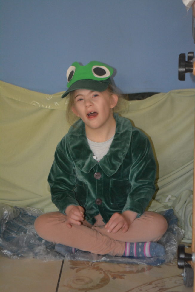 Na zdjęciu siedzi Marysia przebrana za żabkę.