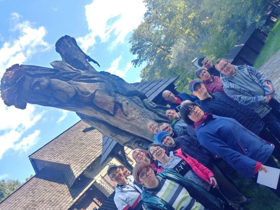 zdjęcie grupowe przy pomniku z drewna