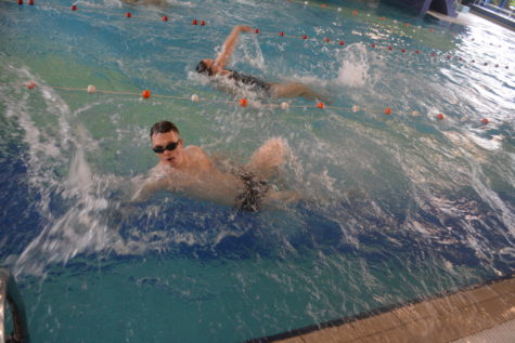 Na zdjęciu chłopak płynie grzbietem w okularach pływackich podczas zawodów.