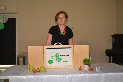 Na zdjeciu Pani bibliotekarka stoi za stołem przed sobą ma teatrzyk z bajką o groszku.