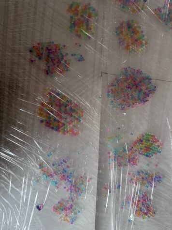 Na zdjęciu widać kolorowe kulki hydrożelowe przykryte folią.